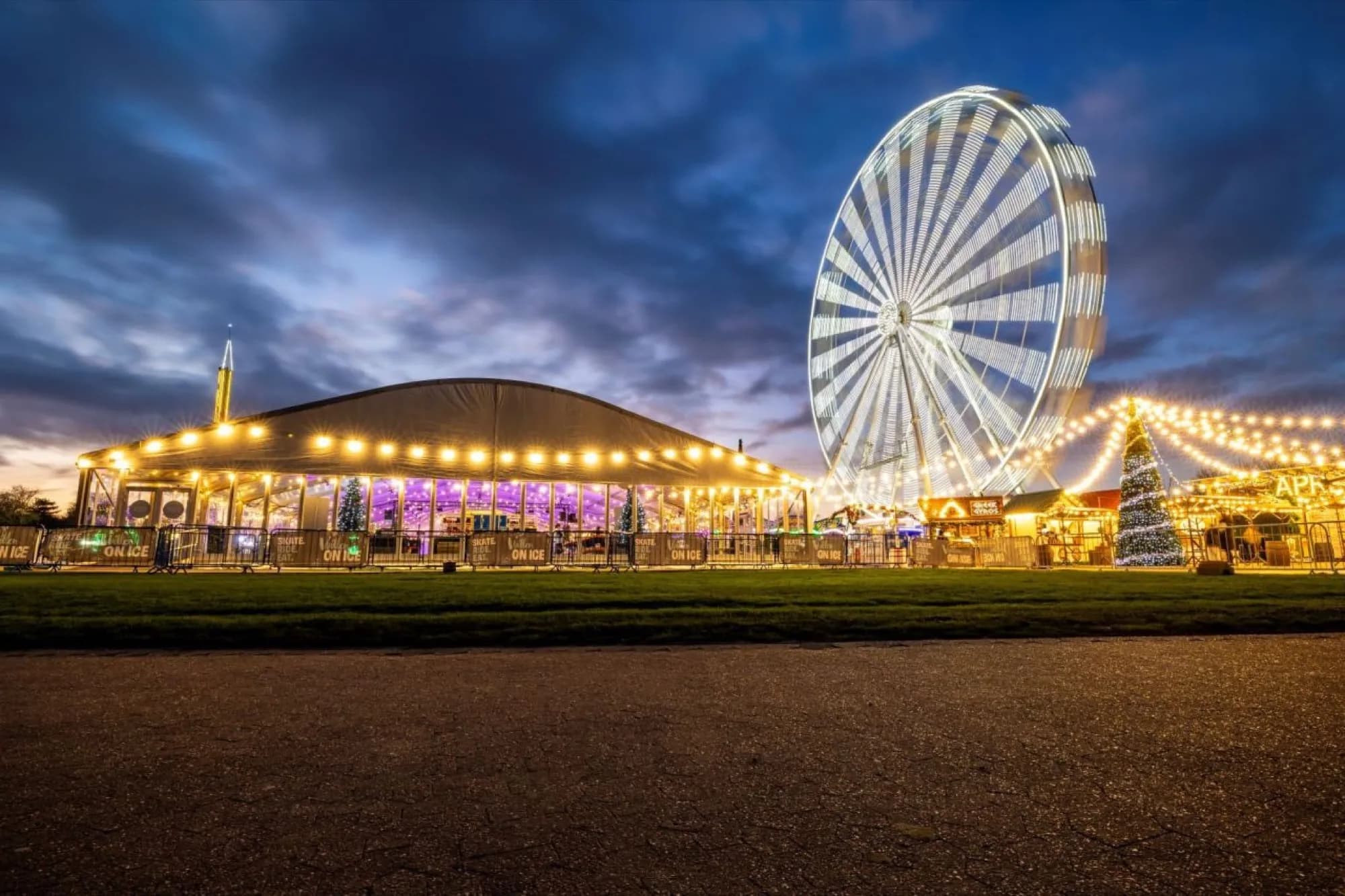 Willen On Ice at dusk: the rink marquee, observation wheel and lakeside fairground