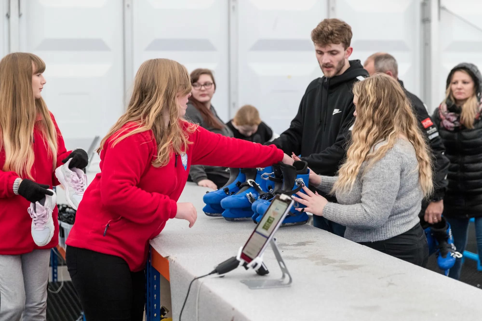 Staff serving customers at the skate hire counter